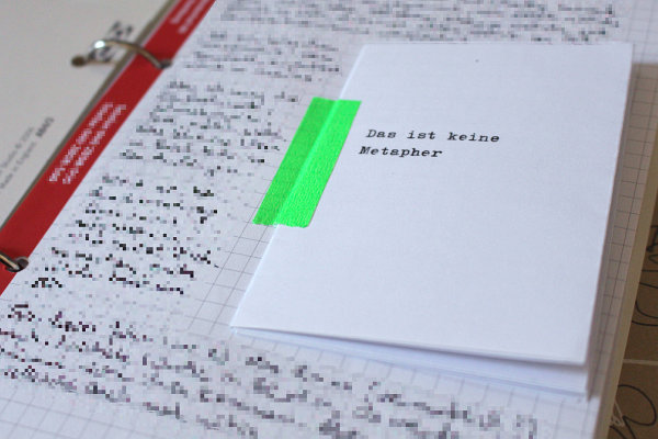 ein kleines Zine mit grünem Washitape auf ein Blatt Papier geklebt